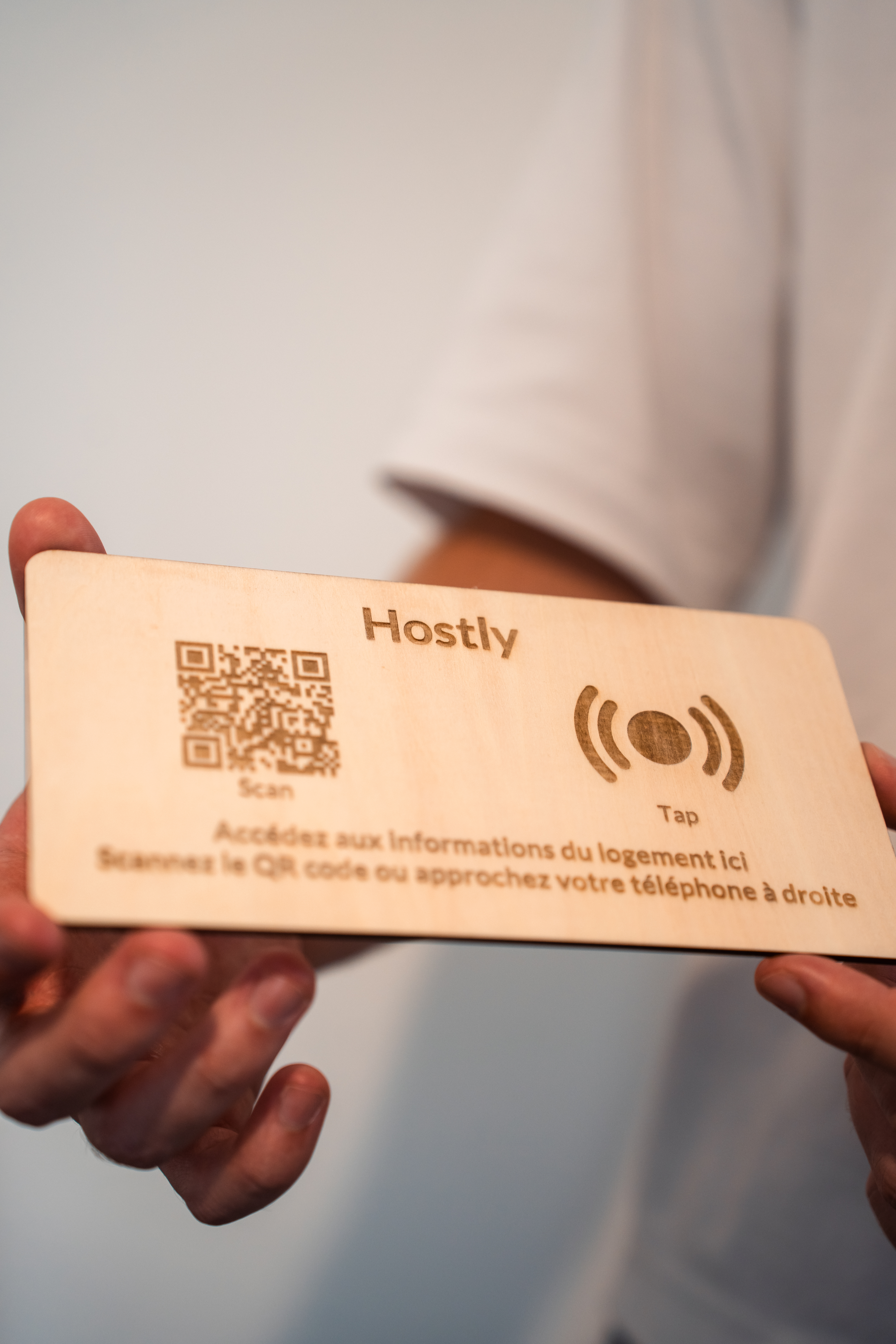 Totem Hostly bois naturel tenu en mains — vue de face