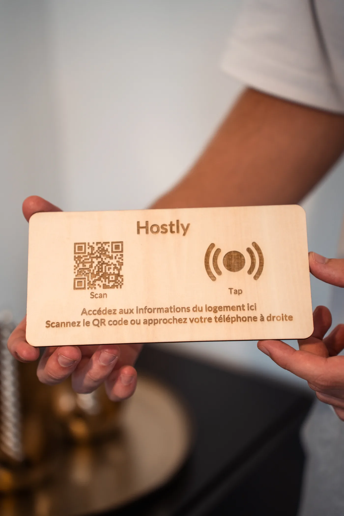 Totem Hostly bois naturel tenu à deux mains, face complète