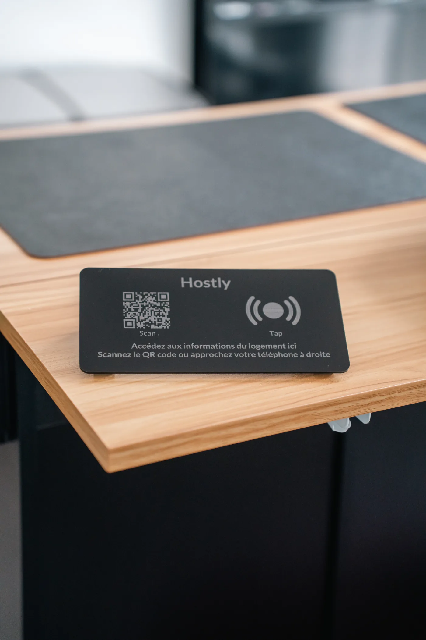 Totem Hostly plexi noir posé sur un bureau