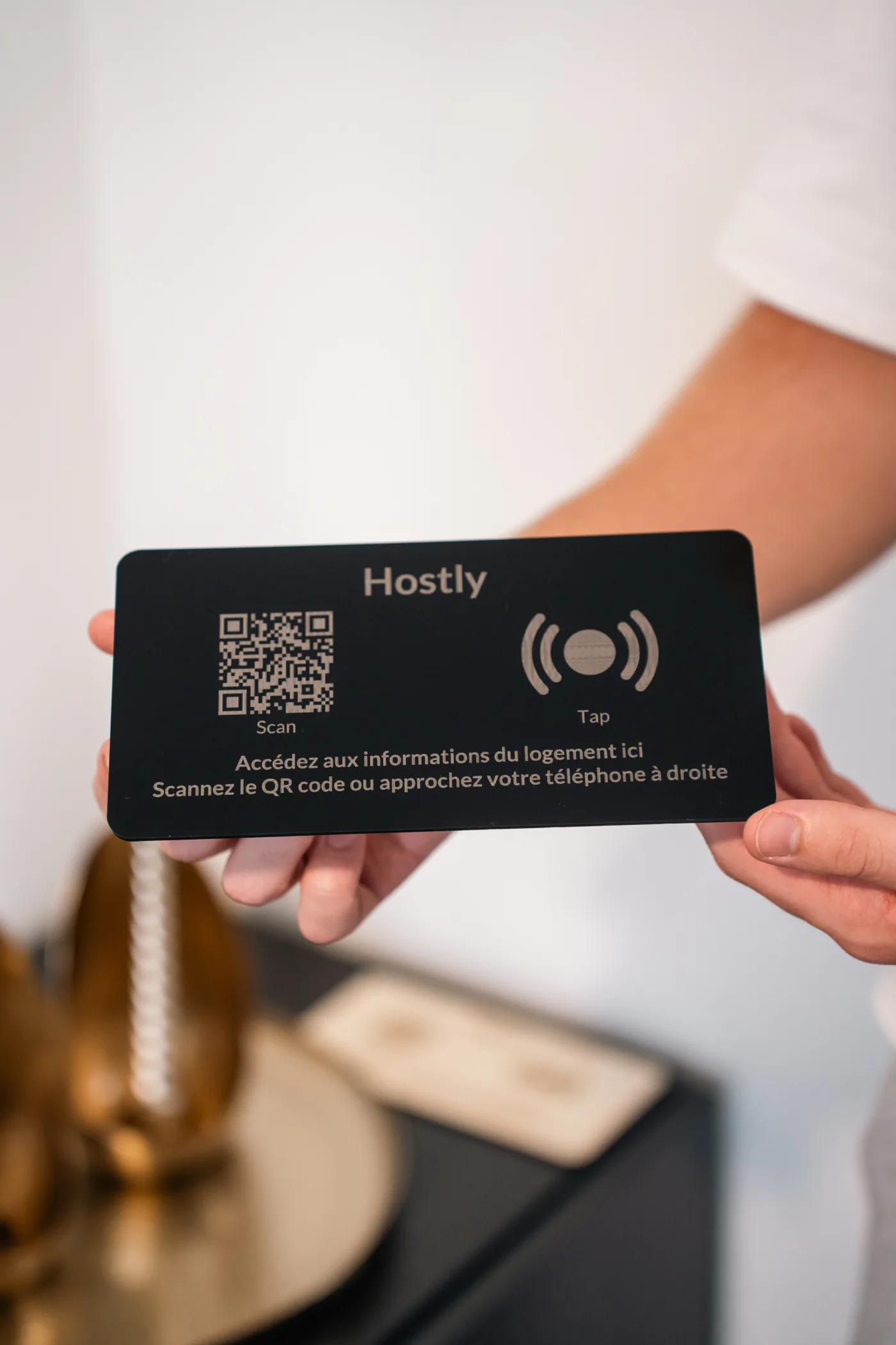 Totem Hostly plexi noir tenu en main, face avant