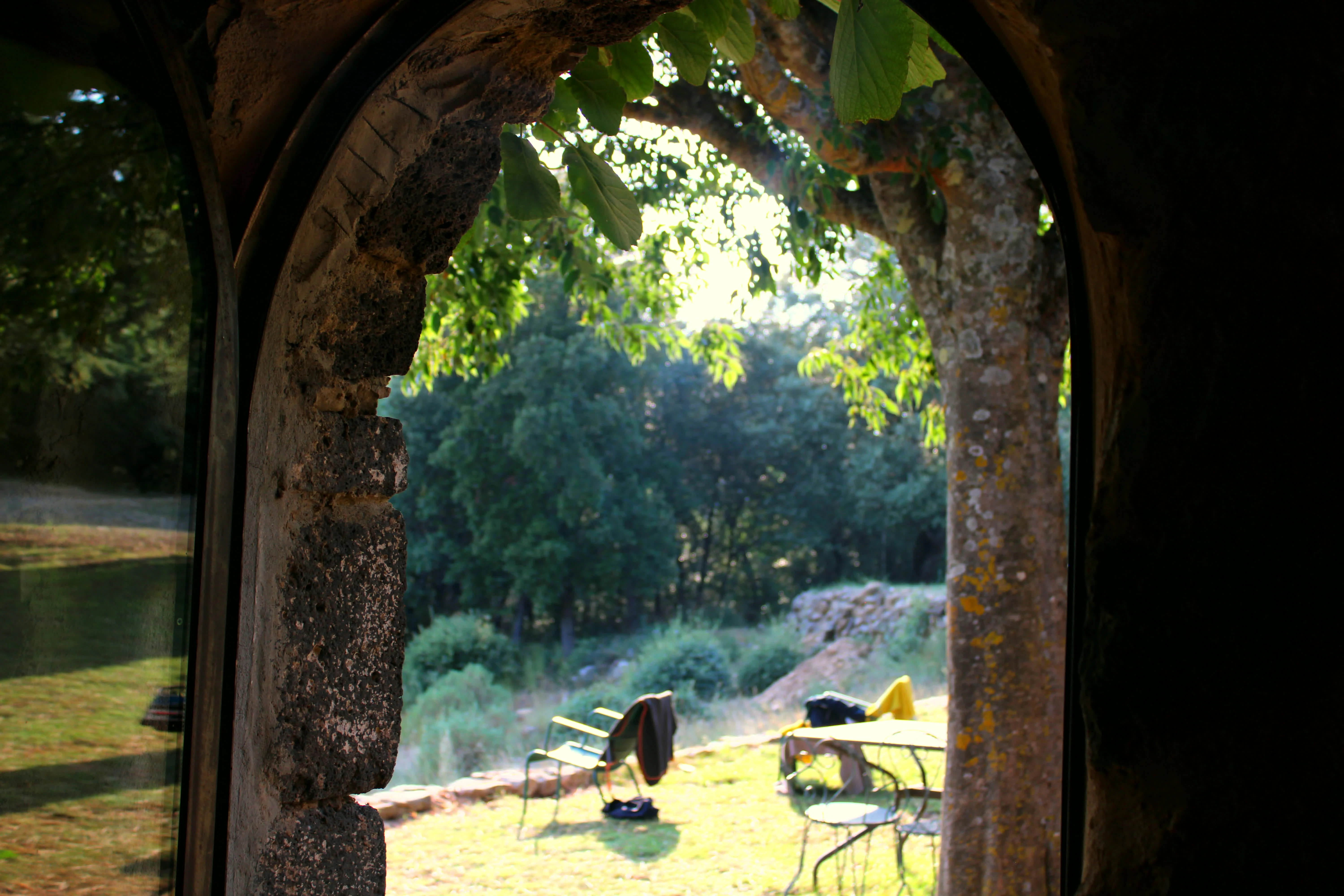 Arche en pierre d'un mas provençal donnant sur le jardin